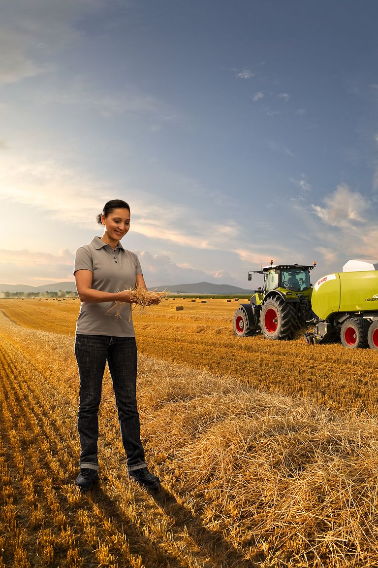professionals-stage-pic Mujer está delante de un tractor en una parcela